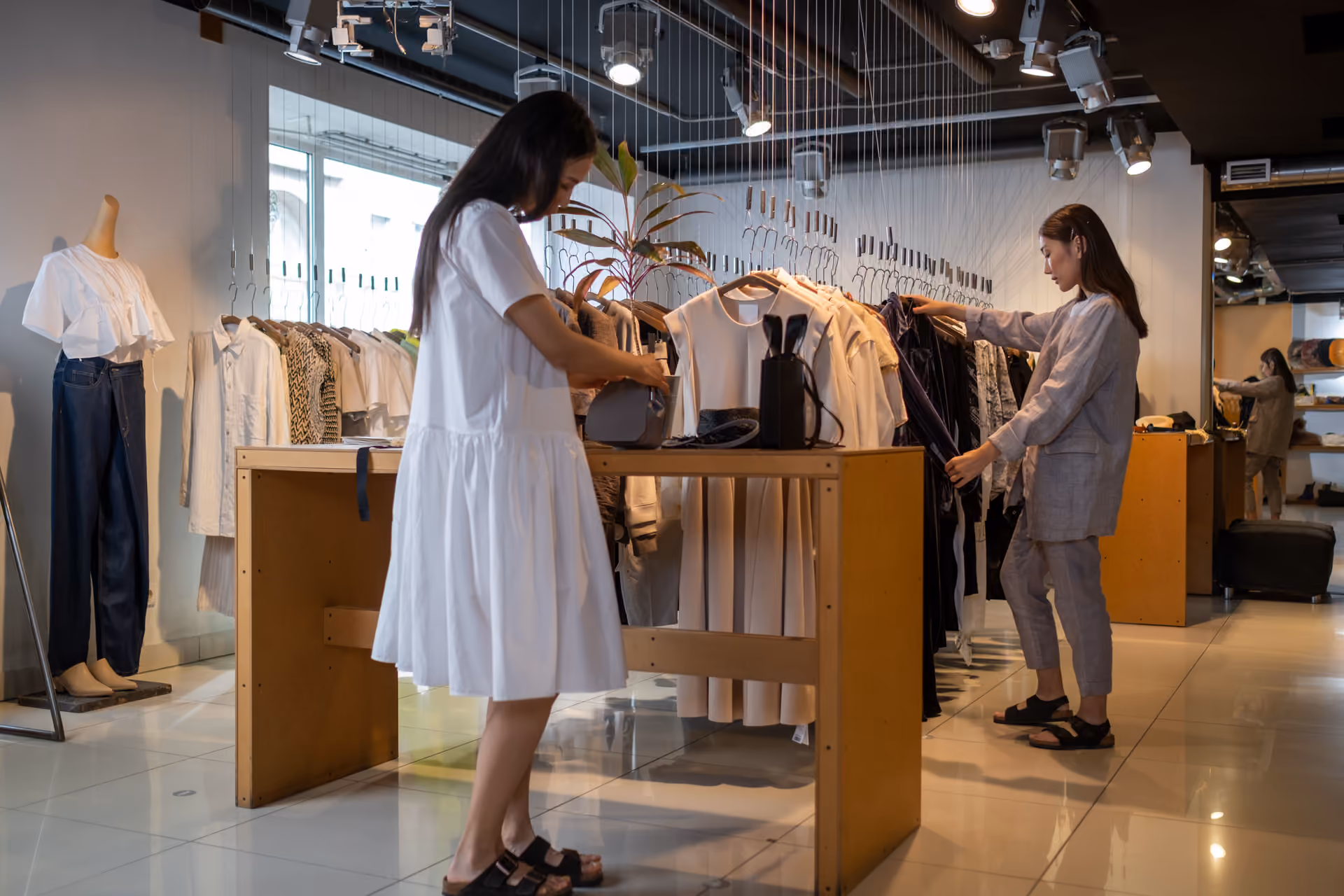 Butikte iki müşteri askılıktaki parçalara bakıyor