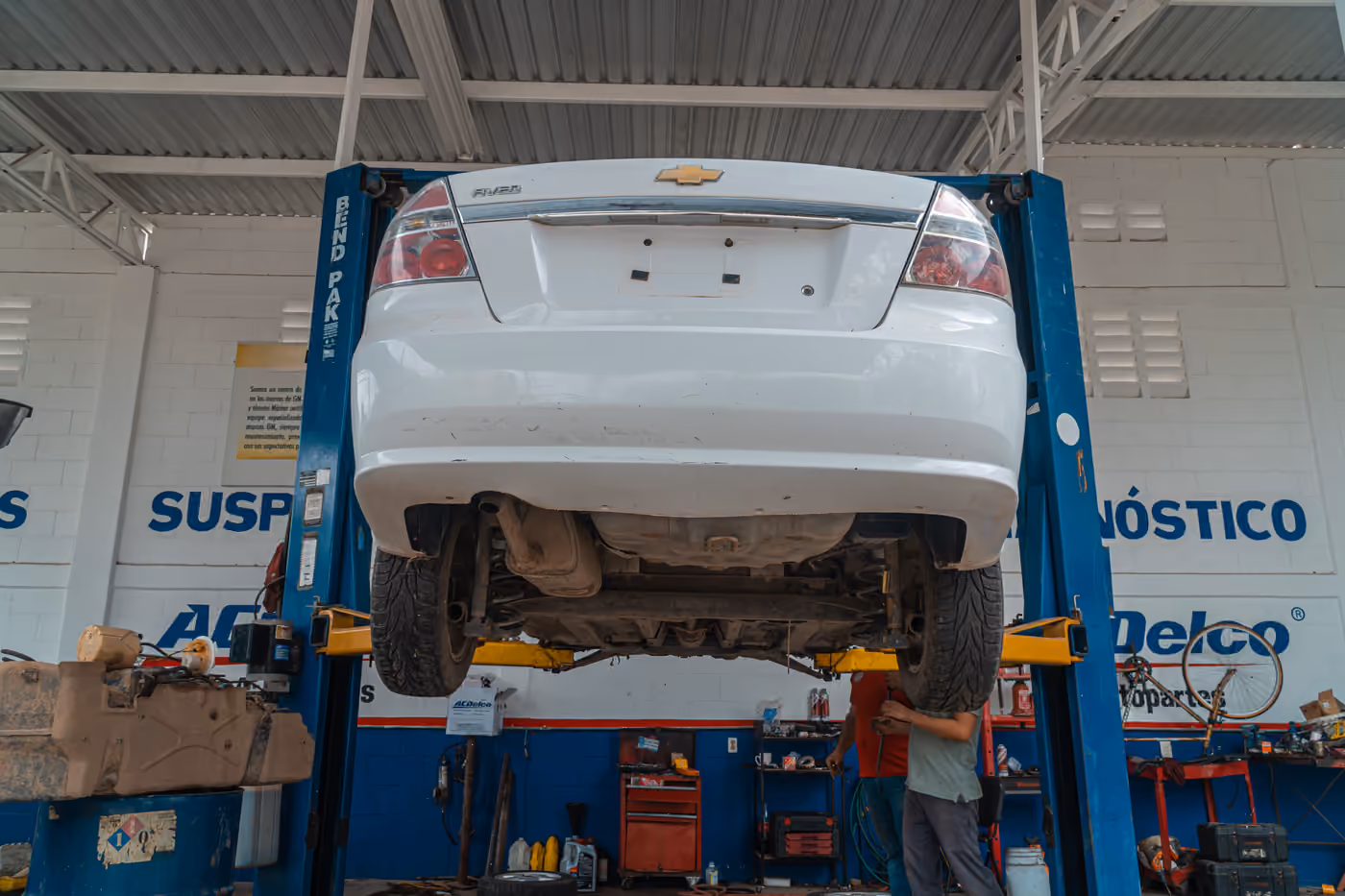 Servis içinde lift üzerinde bekleyen beyaz otomobil